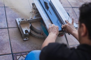 Korumasız eller, elektrikli bir disk ile kesilen bir kalası tutuyor.