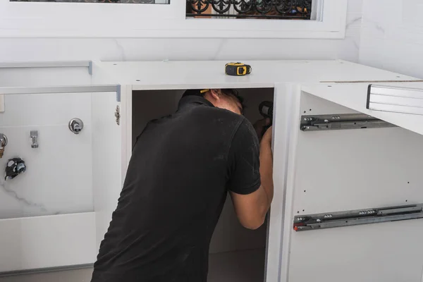 Man assembling a kitchen cabinet — Stock Photo, Image
