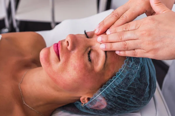 Zijaanzicht van een volwassen vrouw die gezichtsbehandeling krijgt in een spa salon — Stockfoto