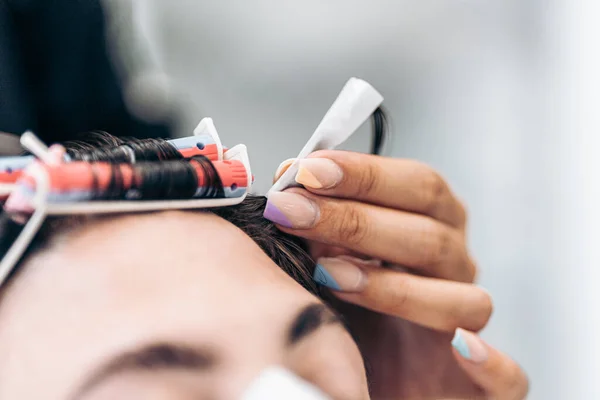 Selektivt fokus på de moderna målade naglarna på en frisör medan du arbetar — Stockfoto