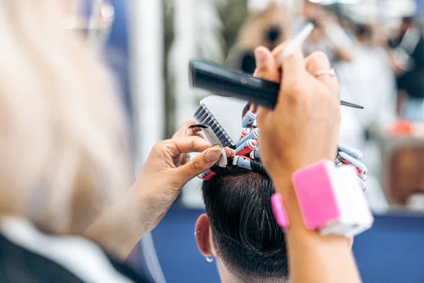 Cabeleireiro fixar um cabelo de clientes com rolos para tingi-lo — Fotografia de Stock