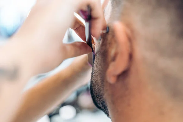 Foco seletivo nas mãos de uma mulher barbeando a barba com uma navalha em um salão — Fotografia de Stock