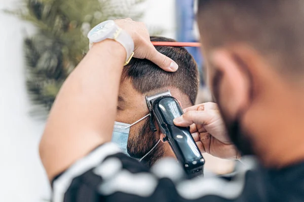 Vista de perto de um homem com máscara sendo raspada em uma barbearia — Fotografia de Stock