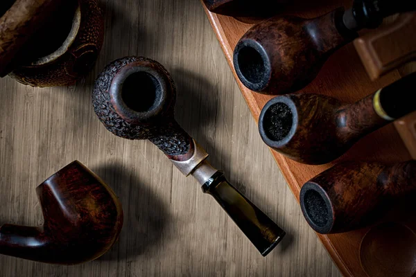 Smoking pipes of different shapes and types in a special rack.