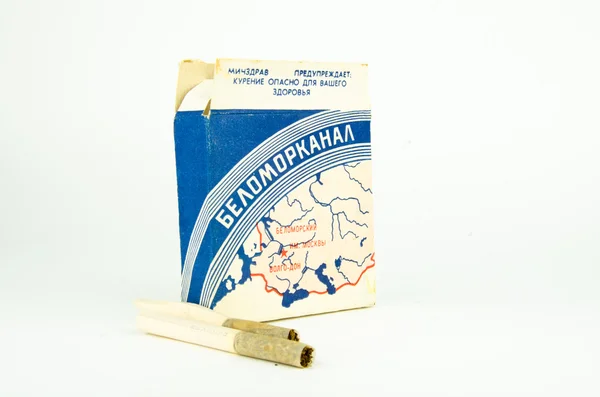 Eski Sovyet vintage sigara Belomorkanal 1930. Retro paket sigara kaba kağıttan yapılmış. Beyaz bir arka plan üzerinde sigara ile eski sigara kutusu.