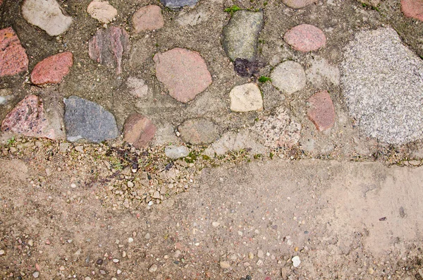 Brick pavement blocks. Cobbled pavement. Green moss on old stone footpath. Road pavement, grass green. Moss trying to grow inbetween cobbled pavement. — Stock Photo, Image