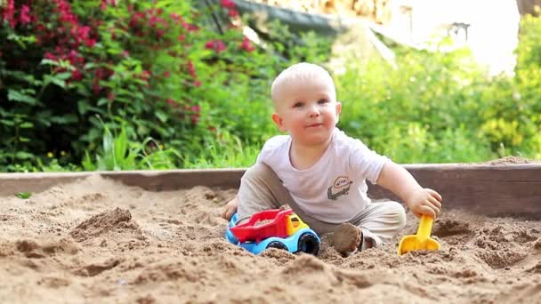 在一个夏日的操场上，可爱的小男孩在公园里玩沙子和五彩缤纷的玩具 — 图库视频影像