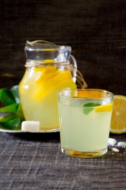 Koyu ahşap bir masa üzerinde taze limon içecek