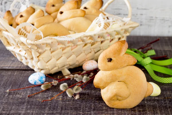 Baking Easter bunny in a wicker basket on a dark background — Stock Photo, Image