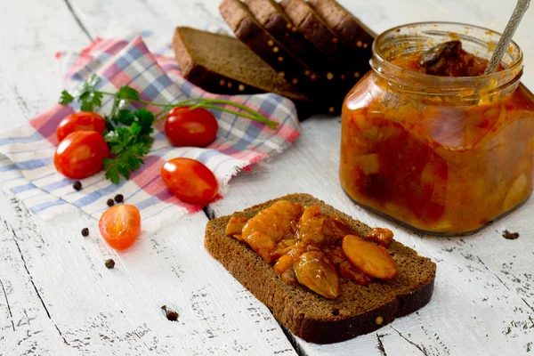 Caviar casero de tomates y frijoles, untado sobre pan, en un rústico —  Fotos de Stock