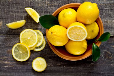 Ahşap bir masa üzerinde bir kapta taze limon