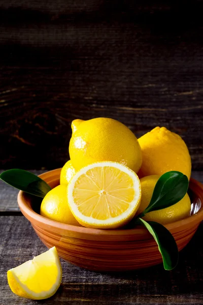 Frische Zitronen in einer Schüssel auf einem Holztisch — Stockfoto