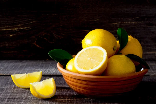 Limoni freschi in una ciotola sul tavolo, spazio per il testo . — Foto Stock