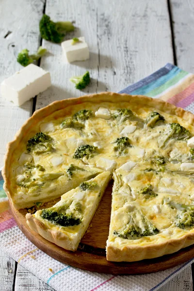 Open pie quiche Lauren with broccoli on a white wooden table — Stock Photo, Image