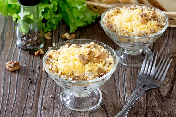 Salada com frango, nozes e queijo em uma mesa de madeira escura — Fotografia de Stock