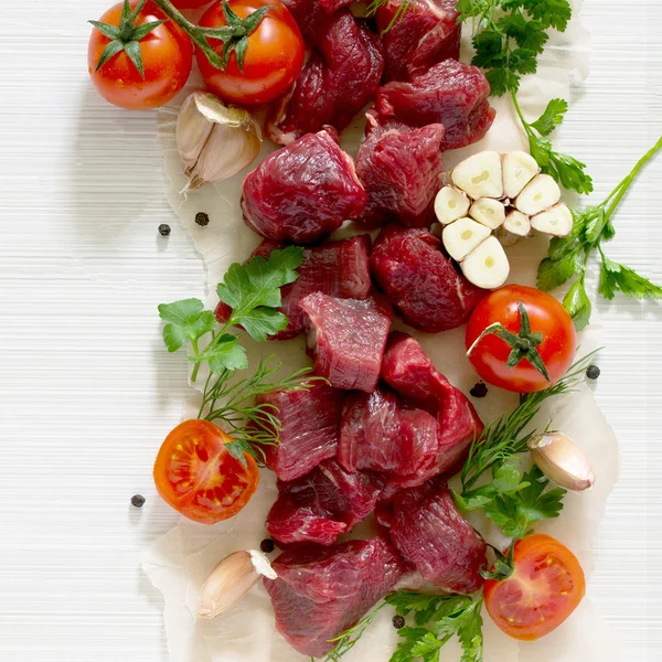 Сире свіже м'ясо, спеції та овочі на легкому дерев'яному фоні — стокове фото