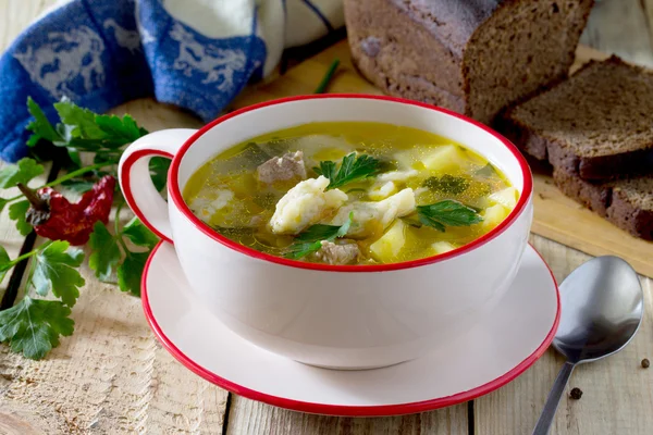 Soup with dumplings and meat, served with rye bread and chili. — Stock Photo, Image