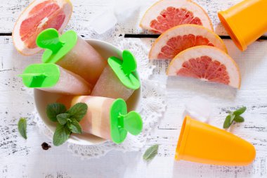 Beyaz ahşap backgrou üzerinde bir greyfurt ile lezzetli meyve buz