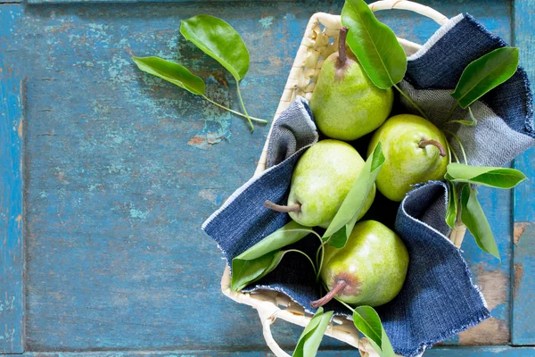 Oogst verse biologische sappige peren in een rieten mand op een rustieke — Stockfoto