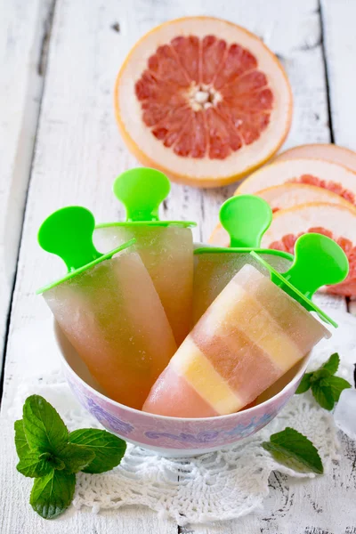 Leckeres Fruchteis mit Grapefruit und Milchshake auf weißem Woo — Stockfoto