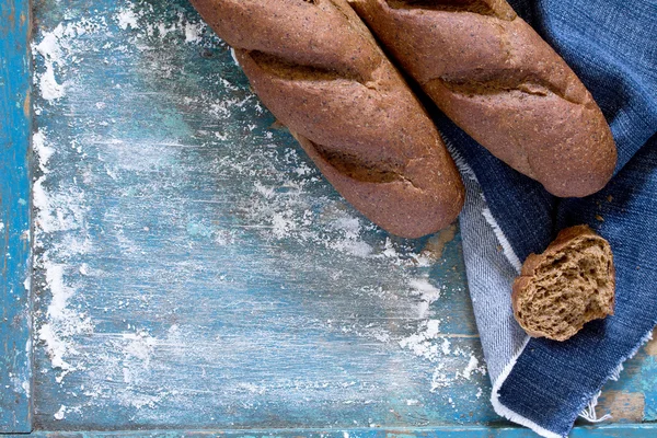 Ржаной хлеб на старинном деревянном синем фоне. Вид сверху  . — стоковое фото