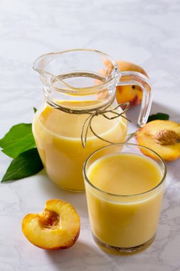 Şeftali süt kokteyli, gri bir taş üzerinde kefir yoğurt ile karıştırılır 