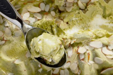 Kahverengi bir taş üzerinde lezzetli dondurma antep fıstığı ve badem yaprakları