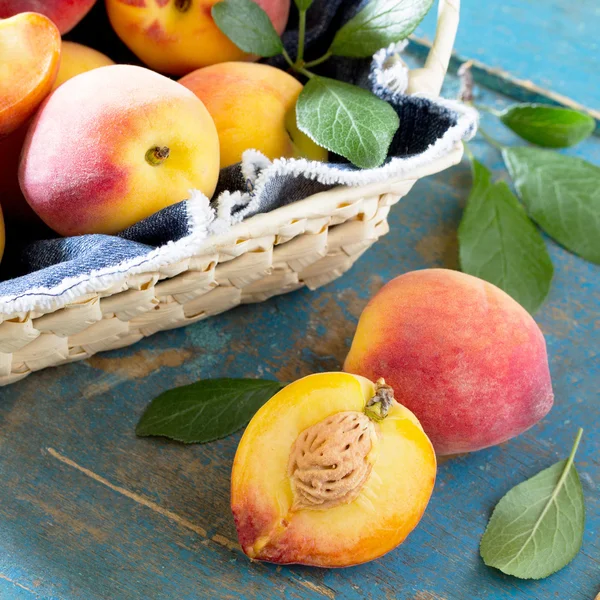 Oogst verse rijpe perziken in een rieten mand op de Vintage WoO — Stockfoto