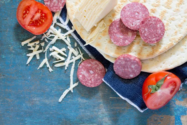 Ingredienti per pizza (pane piatto, formaggio, pomodori e salsiccia ) — Foto Stock