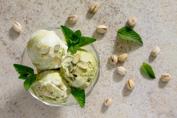 Delizioso pistacchio gelato e petali di mandorle su una pietra marrone — Foto Stock
