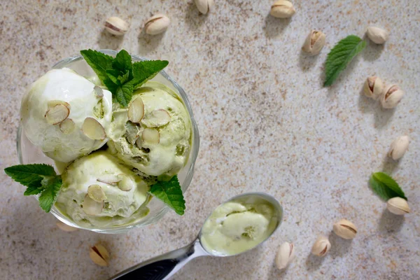 Gelado delicioso pistache e pétalas de amêndoa em uma pedra marrom — Fotografia de Stock