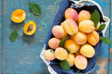Hasat taze olgun şeftali eski ahşap tabl bir hasır sepetiçinde
