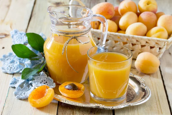 The refreshing summer drink with peach in a jug and glasses on a — Stock Photo, Image