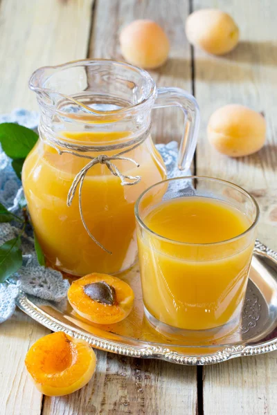 The refreshing summer drink with peach in a jug and glasses on a — Stock Photo, Image