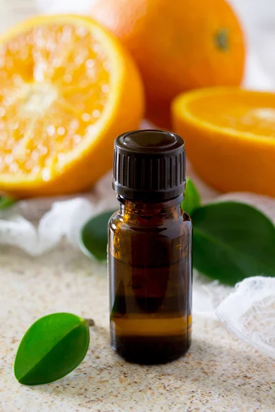 Kahverengi bir taş üzerinde aromaterapi için portakal esansiyel yağı Şişesi — Stok fotoğraf