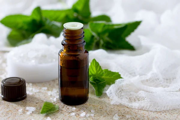 Botella de aceite esencial de menta para aromaterapia en un s marrón — Foto de Stock