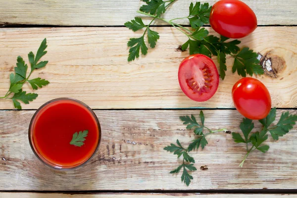 Vaso de jugo de tomate con hojas verdes sobre fondo de madera , —  Fotos de Stock