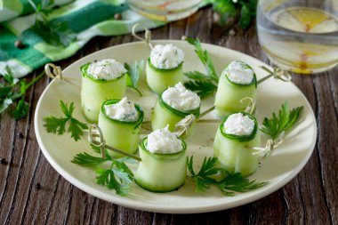 Salatalık wo üzerinde beyaz peynir, dereotu ve zeytin ile doldurulmuş rulo