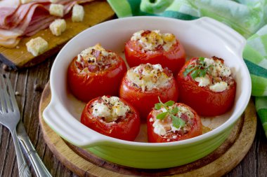 Pişmiş bir ahşap üzerine pastırma ve beyaz peynir ile doldurulmuş domates ta