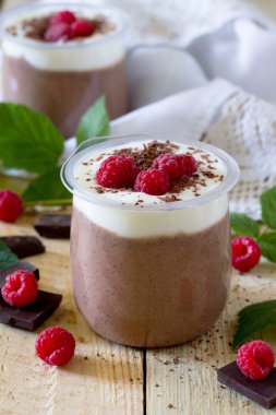 Homemade chocolate mousse with raspberries on a table in a rusti