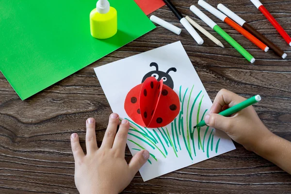Ребенок рисует предметы на бумажной карточке. Ребенок делает открытку с — стоковое фото