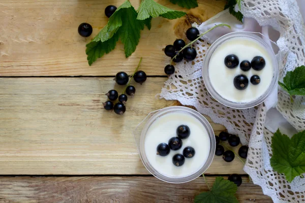 Domácí jogurt s černým rybízu na stole v rustikálním stylu — Stock fotografie