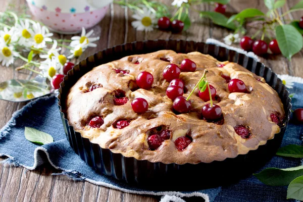 Homemade chocolate cake with cherries and fresh berries on the w — Stock Photo, Image