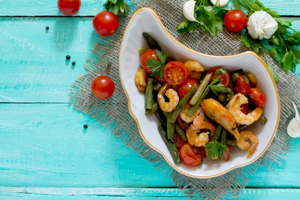 Gebakken garnalen met tomaten, knoflook en groene bonen op een blauwe Vin — Stockfoto