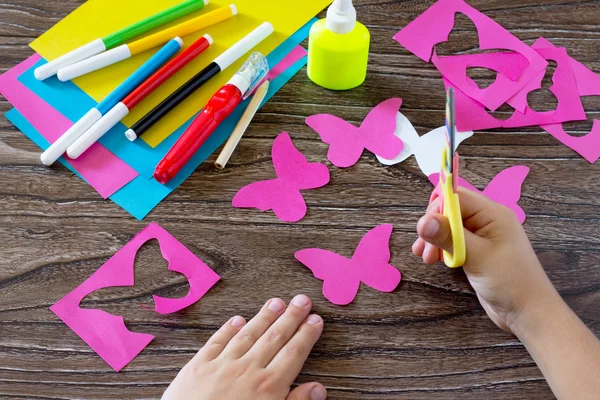 A criança faz a borboleta de papel de papel de decoração em um copo. Qui — Fotografia de Stock