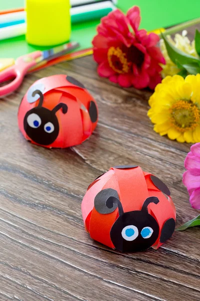Colorful paper for children handmade odd job ladybug on a wooden
