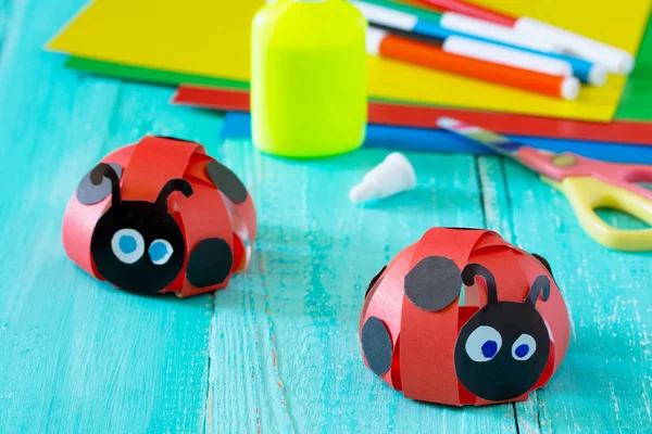 Carta colorata per bambini fatto a mano strano lavoro coccinella su un w blu — Foto Stock