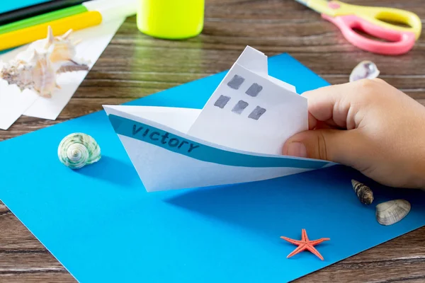 Crafts Paper Boat, origami. Glue, scissors, paper, starfish and