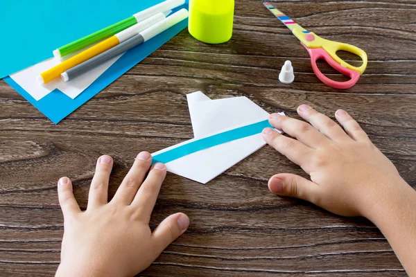 Child glues the paper strip. The child makes crafts out of paper