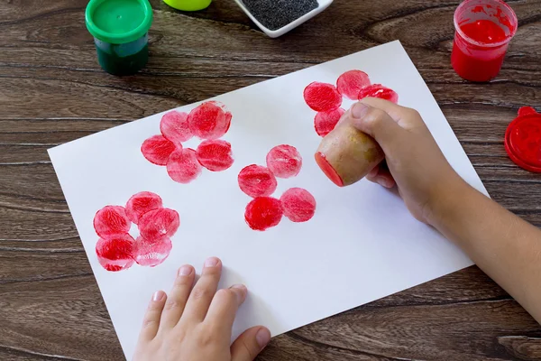 A criança faz desenho em papel usando as batatas de impressão e — Fotografia de Stock